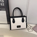 Checkerboard pattern tote bag with dual handles and metal chain strap in modern setting - Black