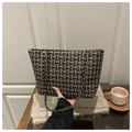 Gros plan sur le tissu en tweed texturé et la bandoulière en chaîne dorée du sac cabas - Noir