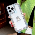 Detail von luxuriösem Strass-Bär und Perlen auf klarer iPhone-Hülle in der Hand - Acryl-Bär mit drei Reihen Strasssteinen / 7Plus/8Plus