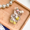 Nahaufnahme einer bärenförmigen Handyhalterung mit Glitzer, Blumen und einem Smiley - Pailletten Gänseblümchen Erdbeere Smiley Bär Stil / Gelb