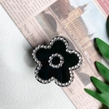 Dettaglio del supporto per telefono a fiore nero con strass scintillanti e finitura di lusso - Fiore di Strass Nero