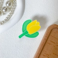 Nahaufnahme einer gelben Tulpen-Handyhalterung auf einem weißen, strukturierten Hintergrund - Gelb