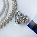 Nahaufnahme der herzförmigen Luxus-Handyhalterung mit funkelnden Mehrschliff-Kristallen - Transparente Basis - Strass-Herz - Reinweiß