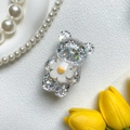 Dettaglio del supporto per telefono a forma di orso con glitter e decoro a margherita - Bianco