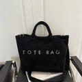 Grote zwarte corduroy tote bag met witte tekstopdruk en een lange schouderband - Zwart