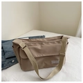 Dettaglio della borsa a tracolla in nylon kaki con etichetta fashion e tracolla regolabile - Cachi