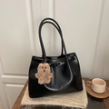 Sac fourre-tout minimaliste en cuir noir avec breloque ours sur un fond en tricot - Avec Pendentif / Noir