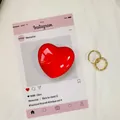 Goldene gedrehte Creolen mit einem glänzenden roten herzförmigen Charme-Zubehör - Rot