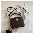 Vue détaillée du sac en cuir marron foncé avec accessoires métalliques en forme de V dorés - Café