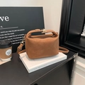 Bolso bandolera vintage marrón con asa y hebilla metálica en un entorno moderno - Marrón
