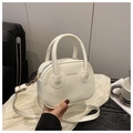 Detail der cremeweißen Lederumhängetasche mit goldener Fashion & Bags Aufschrift auf Holz - Weiß