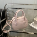 Bolso bandolera rosa de cuero sintético con asas en un entorno de estilo de vida moderno - Rosa