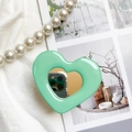 Macro shot of mint green heart-shaped phone grip featuring an integrated makeup mirror detail - Transparent Stand - Heart Mirror - Green / Mint Green