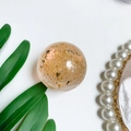Macro-opname van de kristallen bol telefoonhouder met elegante goud- en zilverfolie vlokken - Oranje (Zilverfolie)