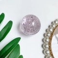 Macro detail van een kristallen bol telefoonhouder met paarse glitters en witte basis - Roze (Zilverfolie)