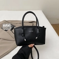 Minimalist black trapezoid handbag with knot handle and silver metal accents - Black