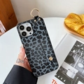 Close-up of leopard print phone case with wrist strap and gold metal ring accent - Black Leopard Wristband / iPhone 7/8/SE 2020