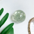 Macro view of crystal ball phone socket with silver glitter inside on a white background - Green (Silver Foil)