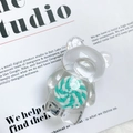 Gros plan du support de téléphone ours transparent avec sucette verte sur un magazine - Vert
