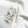 Detailed view of floral bear phone socket on a vintage book page backdrop - White Floral