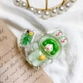 Detail of a cute green astronaut rabbit resin phone grip on a heart-shaped glitter base - Green