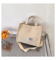 Dettaglio della borsa tote in velluto a coste crema con tasca frontale e tracolla - Bianco Sporco
