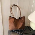 Deep brown suede tote bag with dual shoulder straps shown in a warm indoor setting - Brown