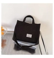 Dettaglio della borsa tote in tela nera con trama del tessuto ed etichetta tessuta Petu - Nero