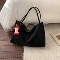 Retro black large-capacity tote bag in suede texture with red apple charm on a white bed - With Pendant / Black