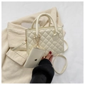 Detail of beige quilted leather handbag with matching mini pouch on textured fabric - Off White