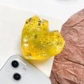 Detailed close-up of faceted yellow heart phone grip with colorful sparkling sequins - Yellow