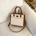 Retro cream and brown crossbody bag with gold hardware on a white sofa setting - Off White