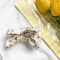Gros plan d'un support de téléphone nœud floral blanc avec tulipes jaunes décoratives - Nœud Floral Blanc