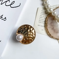 Macro detail of a vintage gold hammered metal phone grip featuring a large white pearl accent - Hammered Pearl Style / Gold