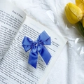 Dunkelblauer Satin-Schleifen-Handyhalter auf einem Vintage-Buch mit Tulpen - Schleife mit Band-Blau
