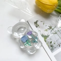 Macro detail of clear bear phone grip featuring 3D embedded blue and purple flowers - Bear Stand - Purple Tulip + Blue Flower