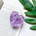 Macro detail of a purple resin heart phone socket with sparkling foil on an open book - Faceted Heart Stand - Silver Foil - Transparent Purple
