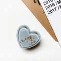 Detalle de soporte de teléfono de corazón azul claro con cuentas en escritorio - Corazón de Perlas con Arena Movediza - Gris
