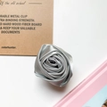 Detailaufnahme einer Satin-Rose Handyhalterung mit silberner Seidentextur und Blättern - Grau