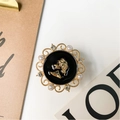 Macro detail of vintage gold relief portrait phone grip with pearls and rhinestones - Black