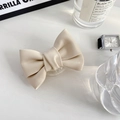 Detail of a creamy white leather bow phone grip with soft textures and pleated design - White