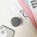Close-up of a round silver glitter phone socket grip on a bright minimalist desk - Silver