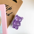 Close-up of cute purple glitter bear phone socket holder on a stylish desk background - Purple