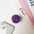 Glitter purple phone grip socket with solid black base shown on white desk surface - Purple