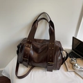 Borsa tote in pelle marrone scuro con rivetti dorati e manico largo su base bianca - caffè