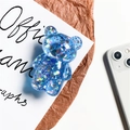 Transparent blue glitter bear phone socket stand with sparkling sequins on paper background - Sapphire Blue