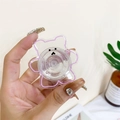 Close-up of a transparent bear-shaped phone grip with purple outlines held by hand - Transparent Pink Outline Bear / Pink