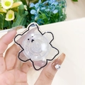 Close-up of a clear bear-shaped acrylic retractable phone grip shown in a hand - Black