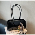 Details der glänzend schwarzen quadratischen Tasche mit schmalen Trägern und Bärenanhänger - Schwarz