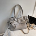 Gros plan du sac cabas gris clair avec cordon de serrage et finitions métalliques - Gris